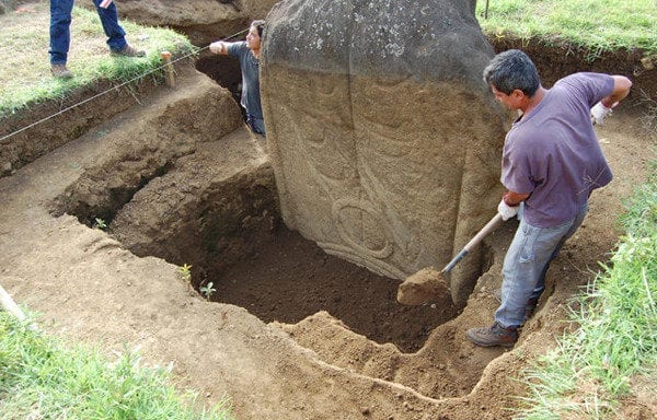 Hombre desenterrando un Moai